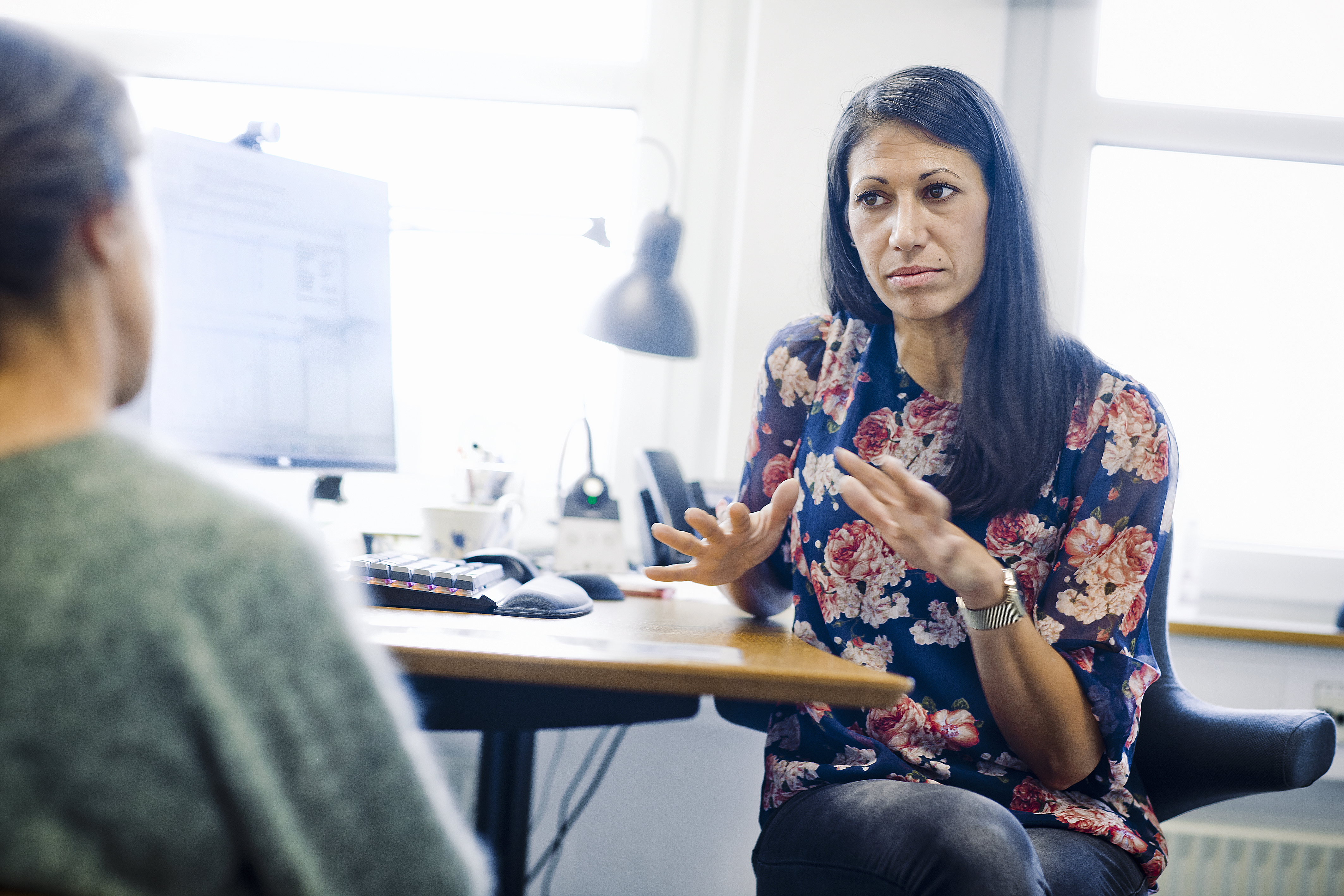 Praktiserende læge taler med patient i Danmark